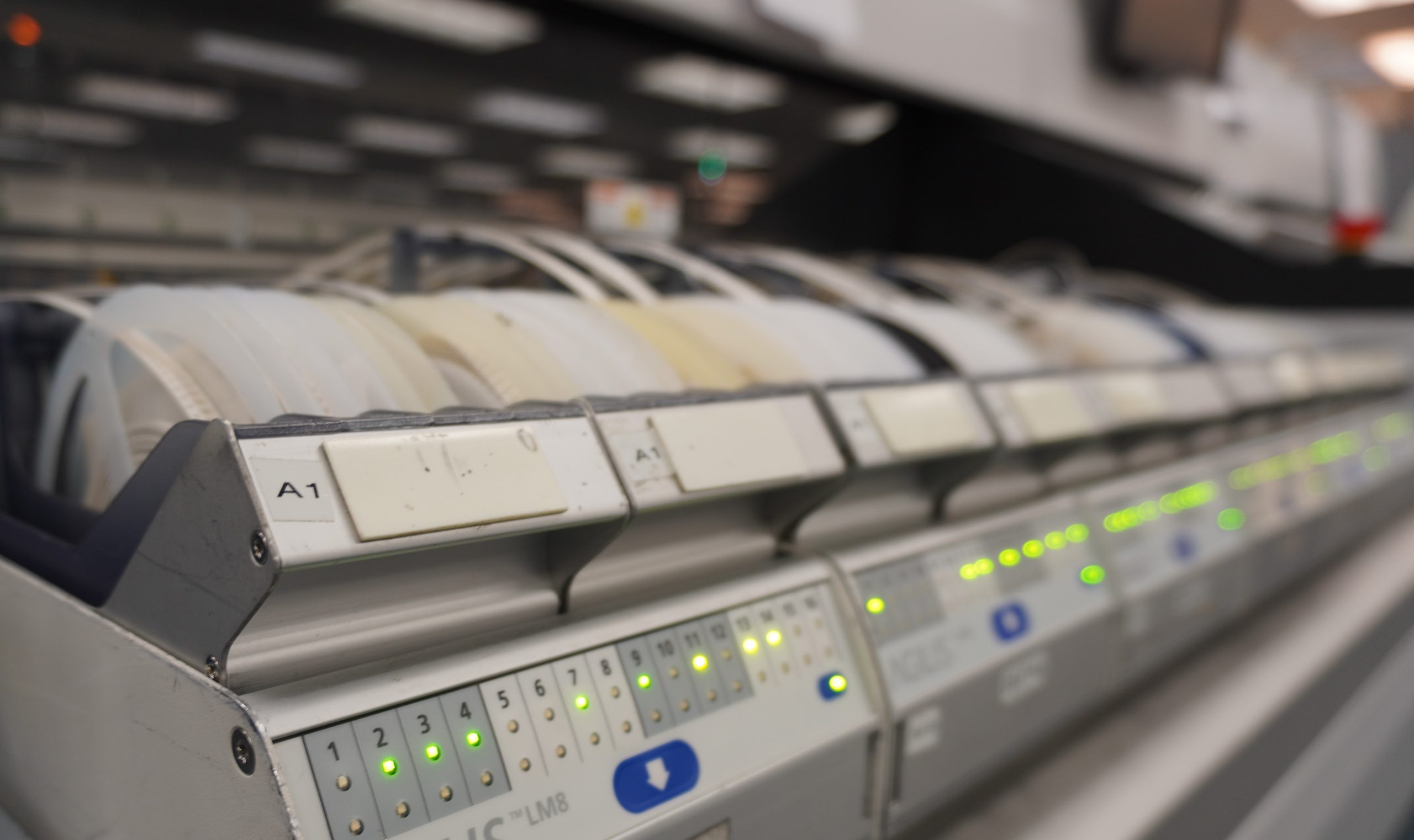 Close-up of an electronic component assembly line with LED indicators in a manufacturing facility, showcasing transforming customer service with AI.